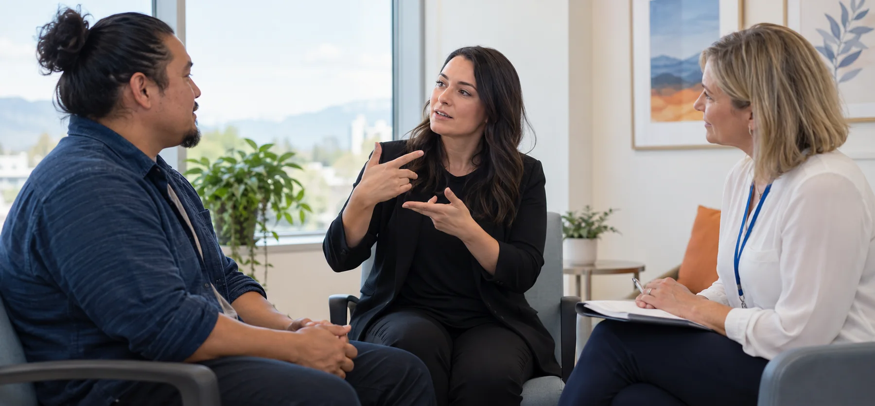 Professional ASL interpreter facilitating communication between a Deaf adult client and a service professional